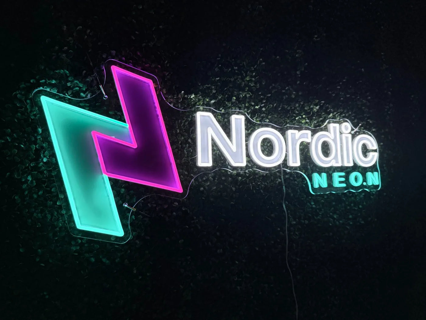 Beleuchtetes Nordic-Neon-Logo mit LED-Neon und UV-Druck auf dunklem Grün